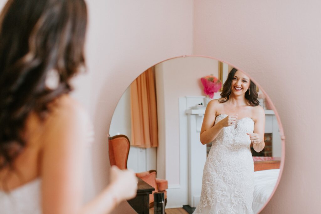 Bride looking at self in the mirror alone